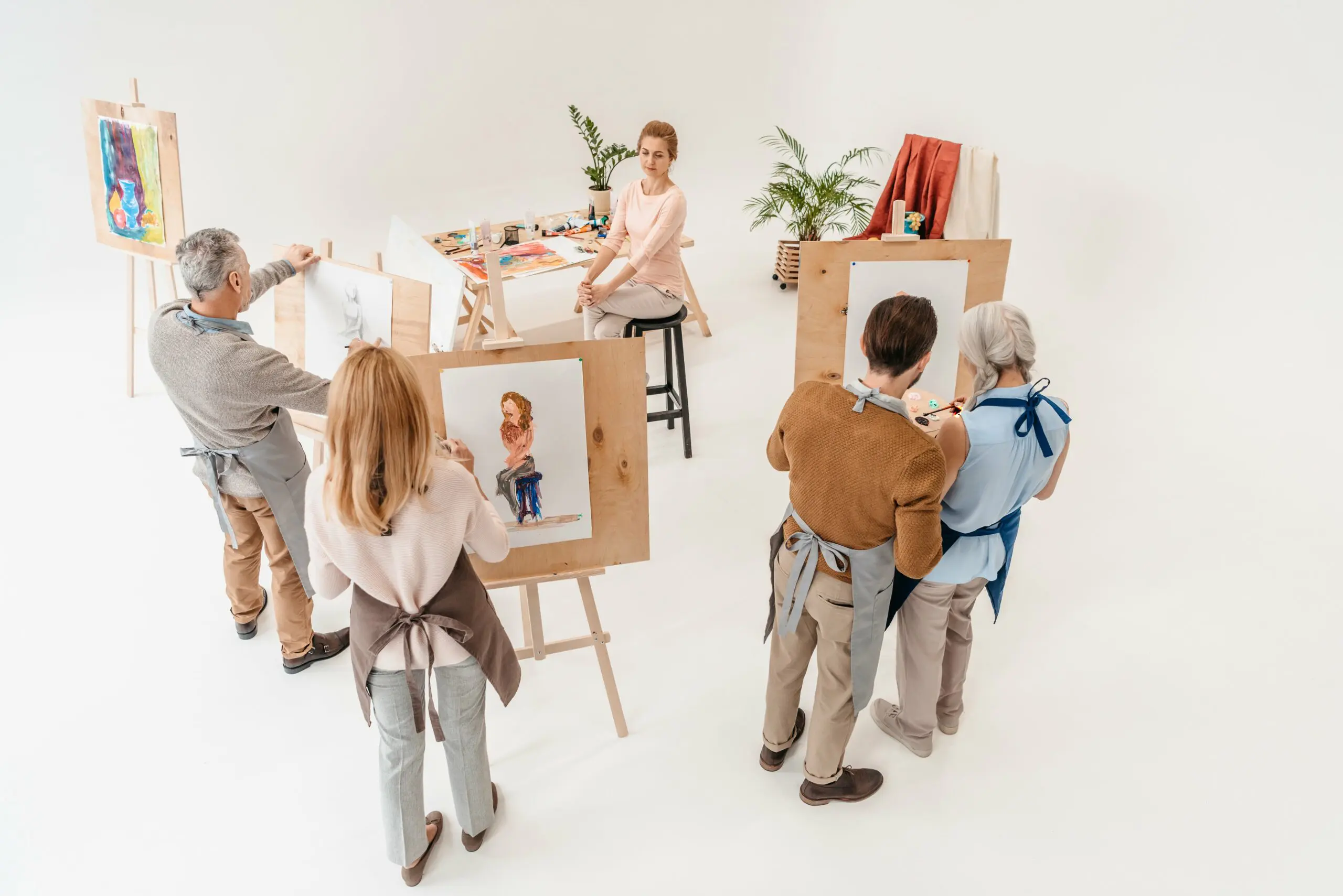 high-angle-view-of-senior-people-painting-on-easel-2023-11-27-04-52-23-utc-min
